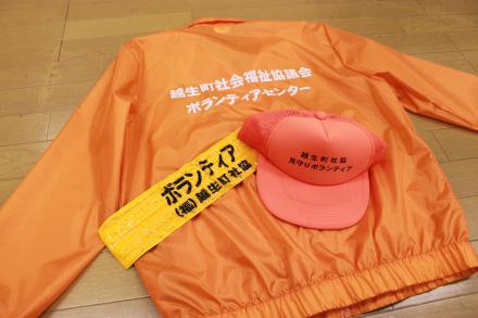 オレンジ色の帽子とオレンジ色の腕章の写真